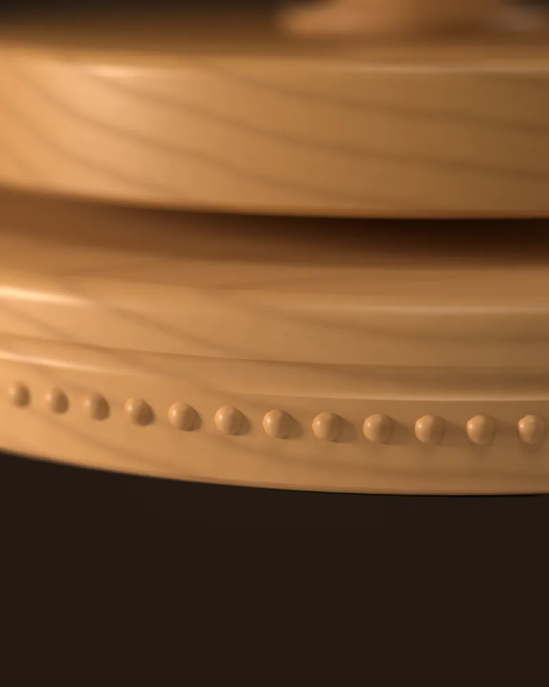 Close-up of the beech base: the grain, a carved groove and a row of beads