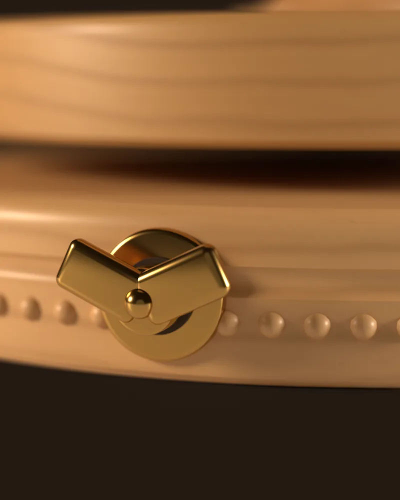 Close-up of the brass wind-up key where it meets the beech base